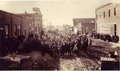 what an image two wagon loads of corn are visible and pens are set up in the middle of the dirt street for livestock there s no identification on the back
