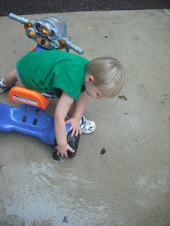 toddler washing big wheel at spray fountains