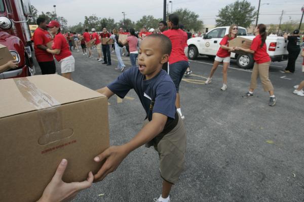 [Gerald+Barnett,+10,+takes+a+box+in+a+human+chain+of+volunteers+preparing+to+handout+boxes+of+food+to+Houston+residents++photo+by+Marcio+Jose+Sanches+AP.jpg]