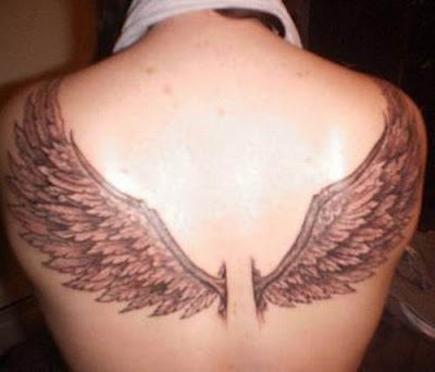 sweeping blue angel wings tattoo with a metalic heart in the centre
