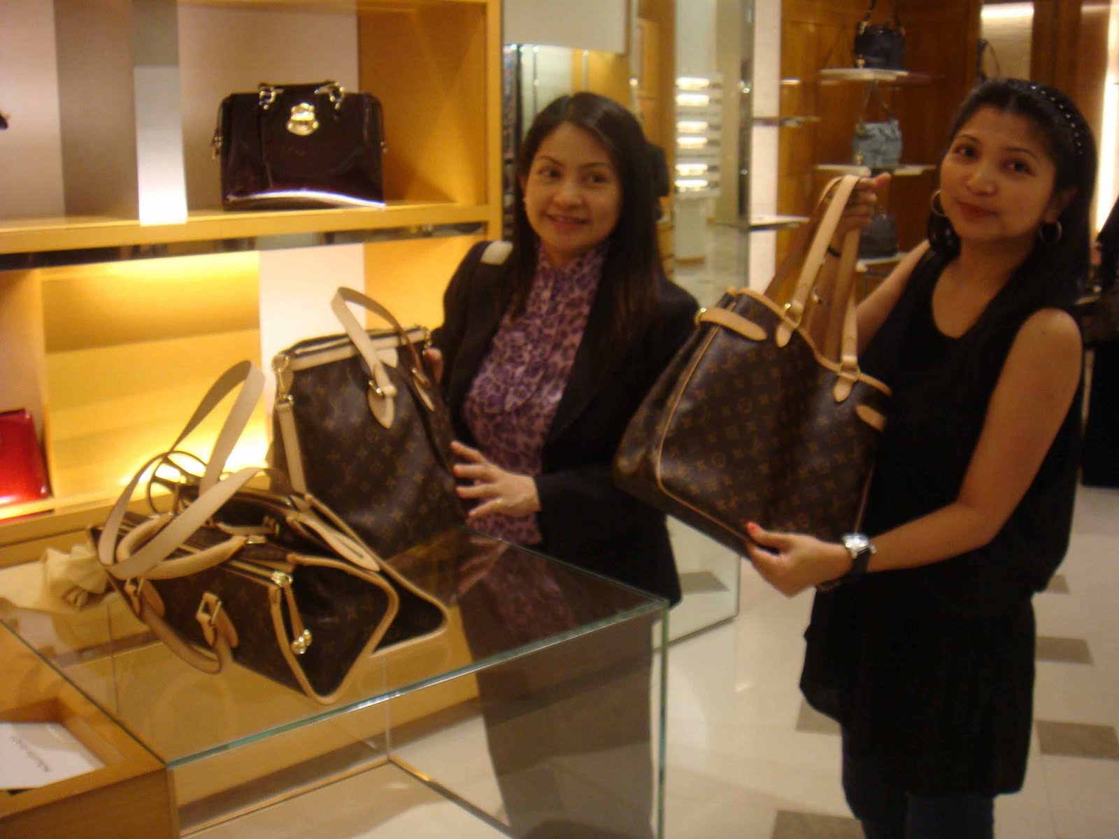 Women shoppers walk past a Louis Vuitton store at the Dubai Mall