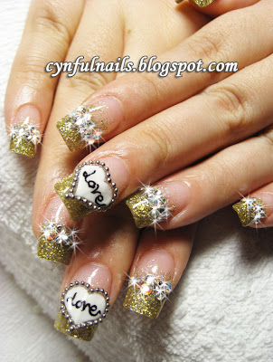 This is an eye-catching and sparkly set of gold nails! The heart design is This is an eye-catching and sparkly set of gold nails! The heart design is