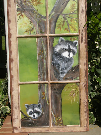 Mom and baby raccoon in a tree on  window