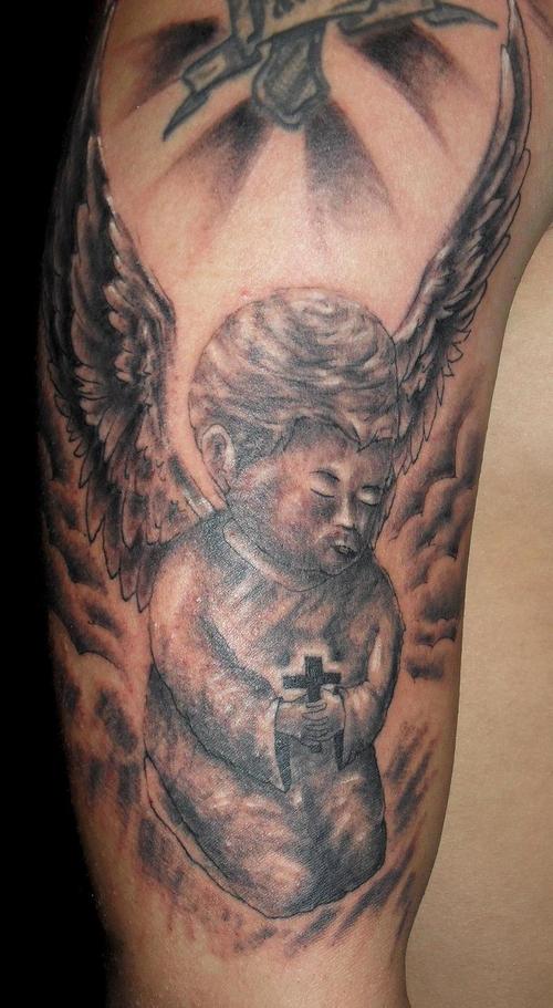 Praying boy angel with large wings tattoo.
