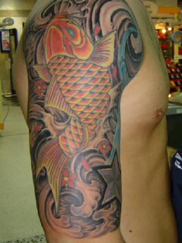 Large koi fish tattoo on upper arm.