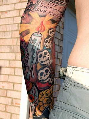 Candle skull tribute arm tattoo.