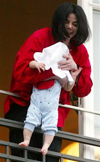 Michael acena com seu filho do lado de fora da sacada para os fãs