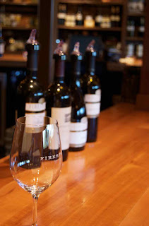 Wine glass in front of wine bottles in the wine tasting room at Firestone