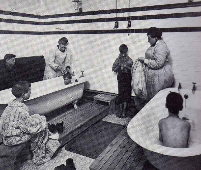 Caption : Verminous slum children being bathed.
