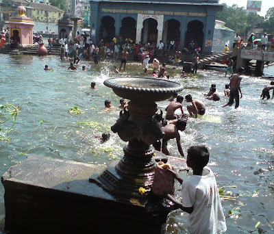 A boy collects holy waters of the river Godavari in Nashik