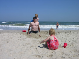 Almost covered in sand and Tyler pours ice water on Papa's back