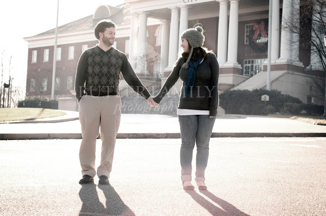 Wide shot of couple holding hands with Roswell City Hall in the background