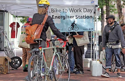 People stop at a booth dedicated to Bike to Work Day at Battery and Market Streets in San Francisco