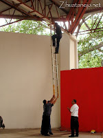 A fireman descends the too-short ladder while his buddies hold it