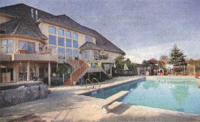 Large pool overlooked by badly designed back of a suburban house