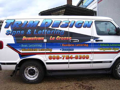 Full-size van with lettering advertising a business called Trim Design Signs & Lettering. Super ugly!