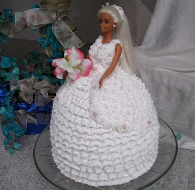 Tanned blonde Barbie doll emerges waste up from a frosting-covered white skirt