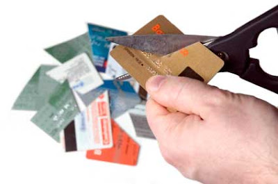 Hands cutting up credit cards with scissors