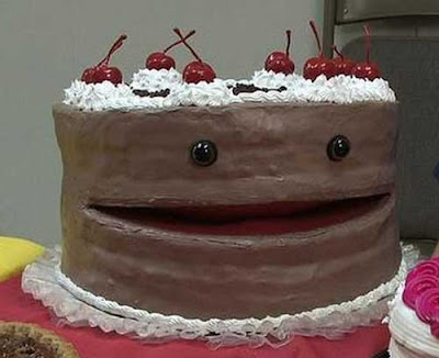 Cake with chocolate frosting, two round eyes on the side, and an opening between the two layers that looks like a mouth