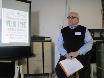 Paul Gehl beside a projected screen of a wood type specimen book title page