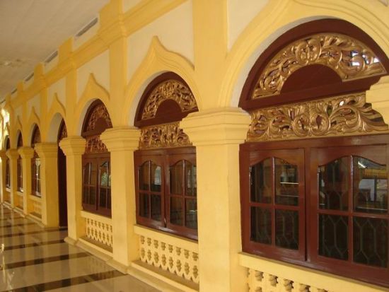 Dinding mesjid yang berbentuk unik dan jendela yang dibenuhi ukuran bermotif Melayu