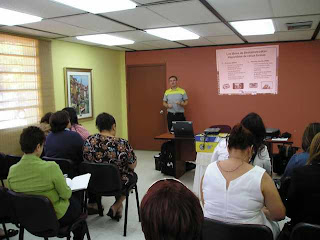 Paddy standing at the front of a classroom with students in desks.