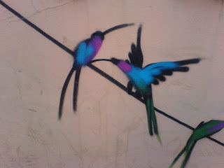 graffiti of 2 blue and purple birds on a wire