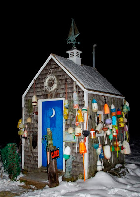 An outhouse decorated with buoys that serves as an entrance hut for a Granby, Mass Christmas tree farm