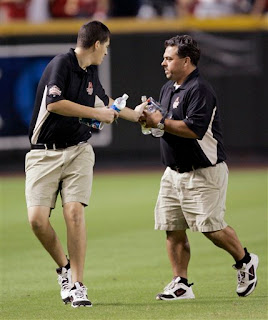 workers pick up bottles being thrown onto the field