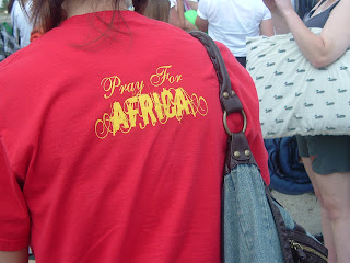 Gold colored text saying ''Pray for Africa'' on the back of a red t-shirt worn by a Displace Me participant in Austin