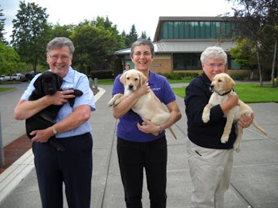 Volunteers holding the puppies that would be presented to their new raisers at an Oregon graduation ceremony