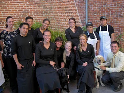 The Melting Pot staff pose with a couple of GDB puppies in training