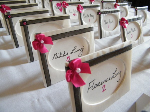 The pink ribbons on the name cards which were fabriccovered picture frames The pink ribbons on the name cards which were fabriccovered picture frames