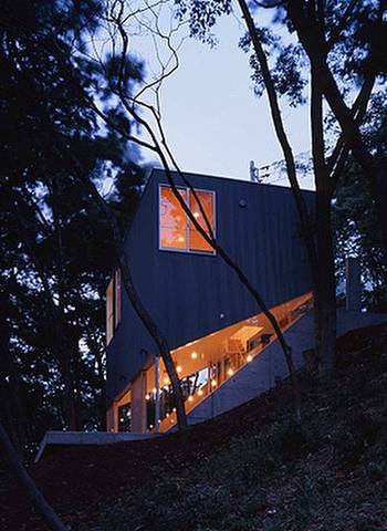 Arquitectura de casas: cabaña vanguardista de madera sobre pendiente.