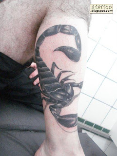 Escorpião preto tatuado na perna.