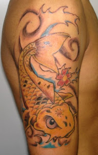 Carpa dourada tatuada no braço