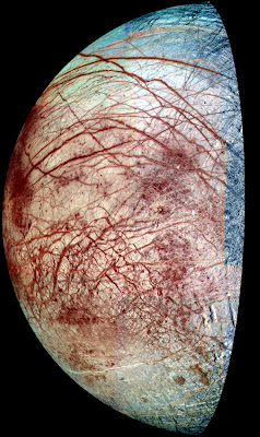 The icy surface of Europa is shown strewn with cracks, ridges and