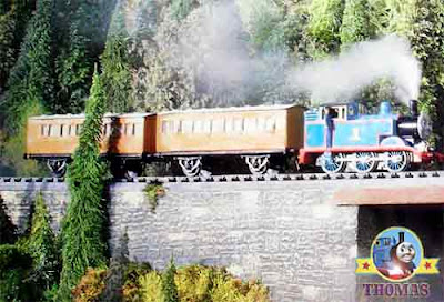 The train Percy and Thomas the tank engine happy puffing along the hillside mountain railway tracks