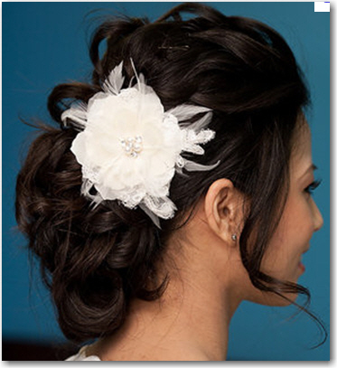 An elegant updo with a combination flower feather accessory
