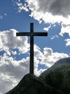 Wooden Cross on hill with clouds of Christian religious background in the blue sky