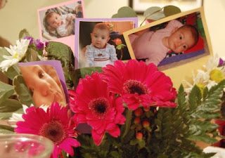 Baby picture cutouts standing in a center of flowers