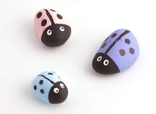 Rocks painted as a pink, blue, and purple ladybug