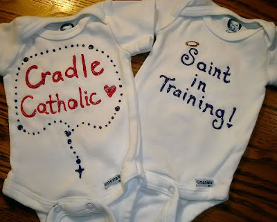 Onesies reading "Cradle Catholic" and "Saint in Training"
