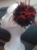 Flor de organza negra con plumas rojas: un bonito detalle para una boda de noche.