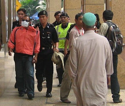 Police bringing an arrestee next to OCBC bank heading towards Masjid Jamek Police bringing an arrestee next to OCBC bank heading towards Masjid Jamek