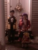 all three kids standing in front of their last house for trick or treating