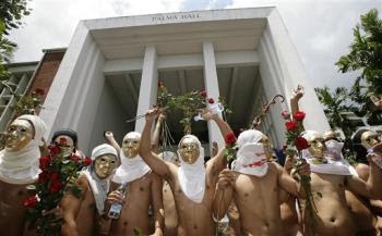 Members of the Alpha Phi Omega fraternity gesture as they run naked inside the campus to mark the 100th year anniversary of University of the Philippines in suburban Quezon City, north of Manila, Wednesday, June 18, 2008. (AP Photo/Aaron Favila)