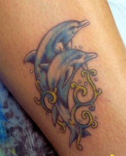 Golfinho tatuado na perna, saltando na agua golfinho tatuado na perna