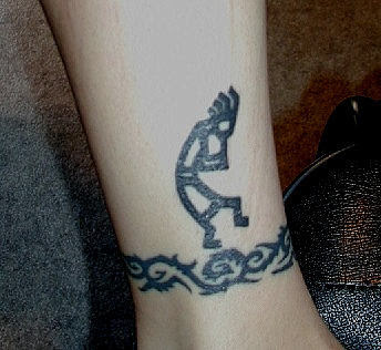  tattoo de Kokopelli ornado por uma pulseira tribal no tornozelo