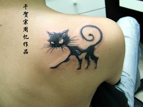 A skinny and angry cat tattoo below the shoulder